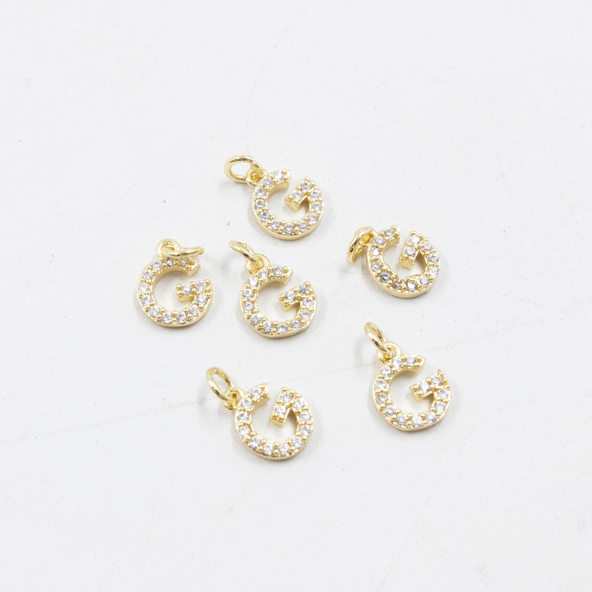 Paquete de 6 Dijes de Letras con piedras M2 Oro Laminado
