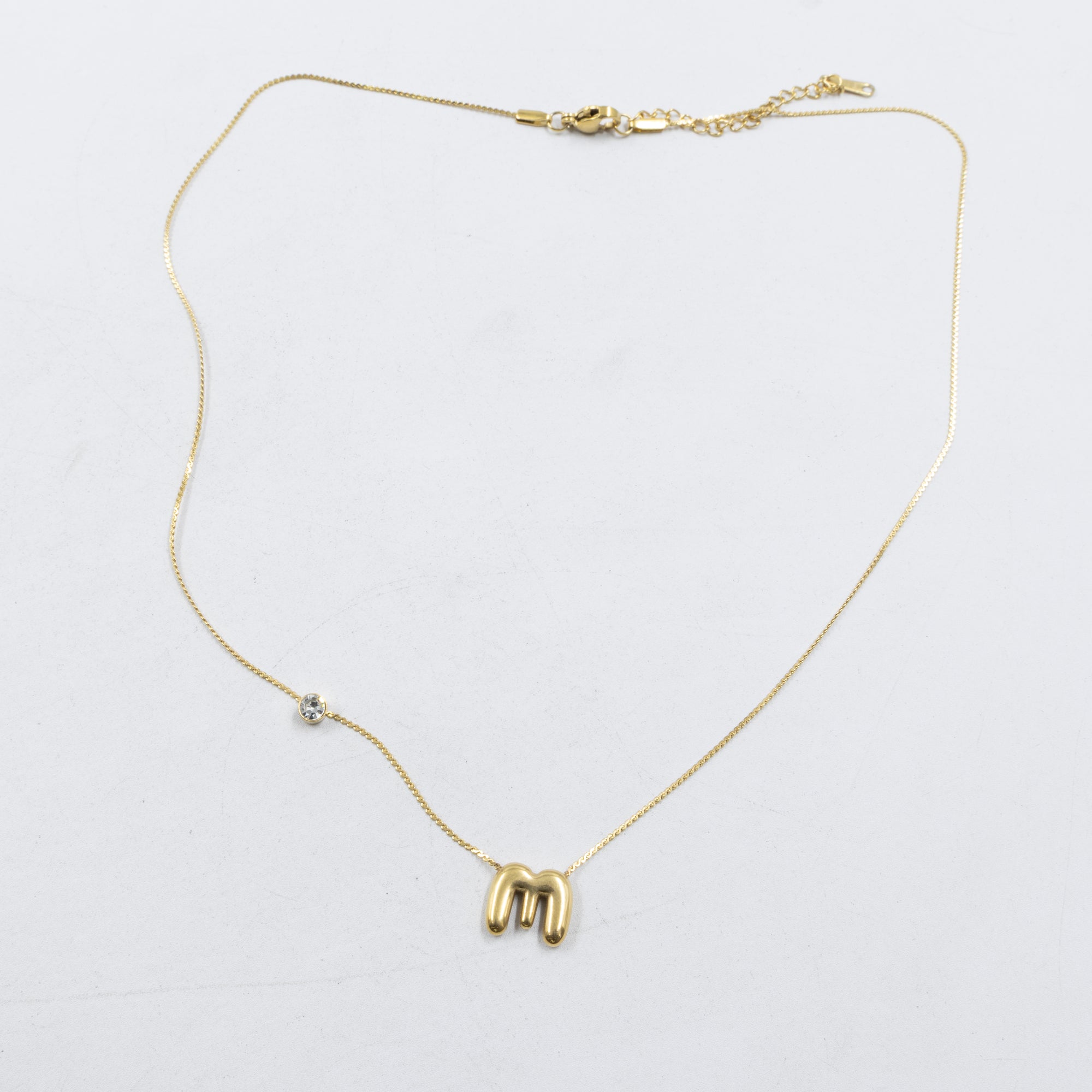 Collar Dorado con Dije de letras pequeñas M2 Oro Laminado