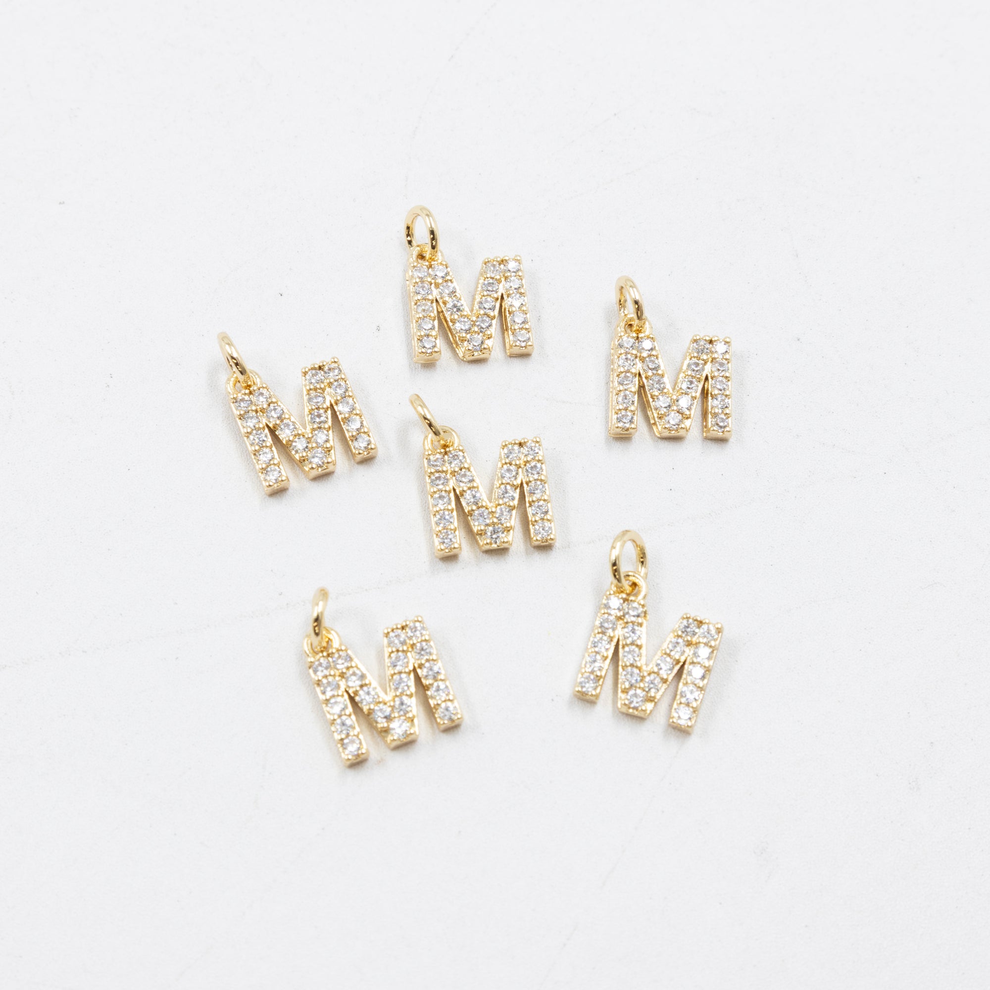 Paquete de 6 Dijes de Letras con piedras M2 Oro Laminado