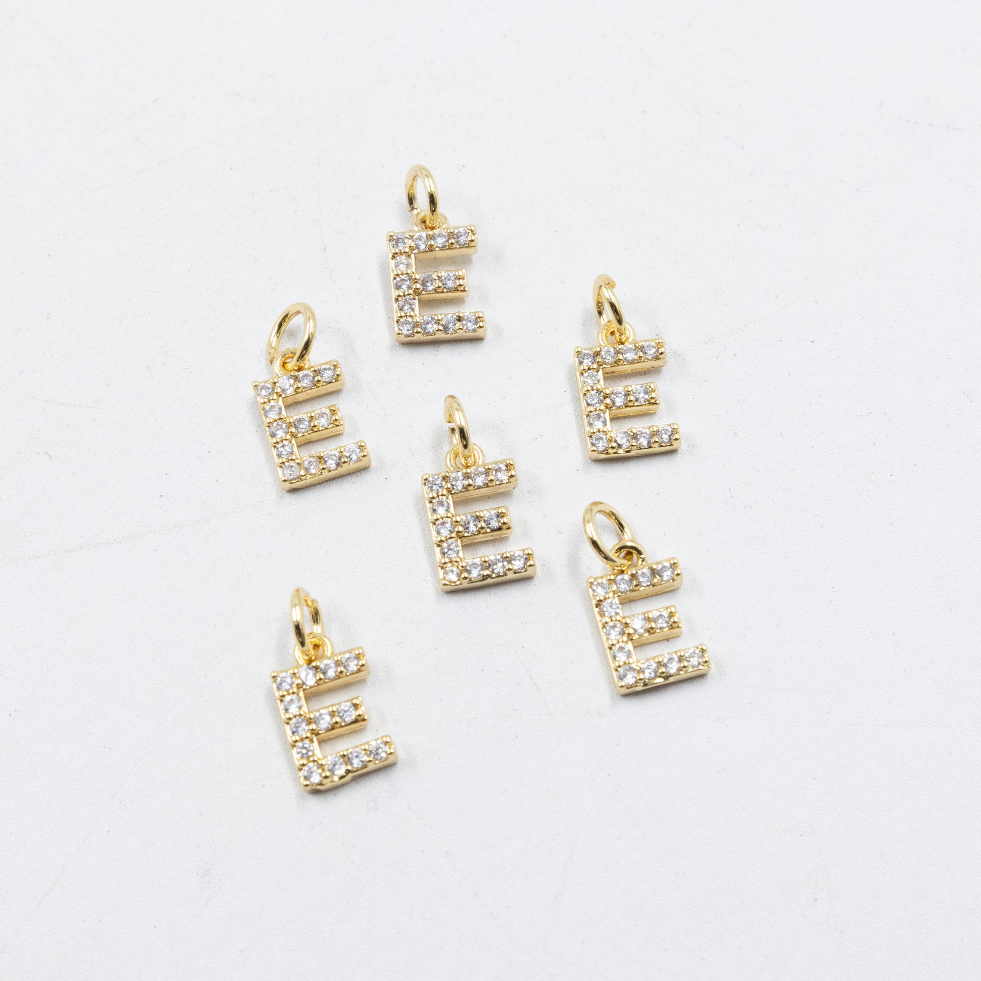 Paquete de 6 Dijes de Letras con piedras M1 Oro Laminado
