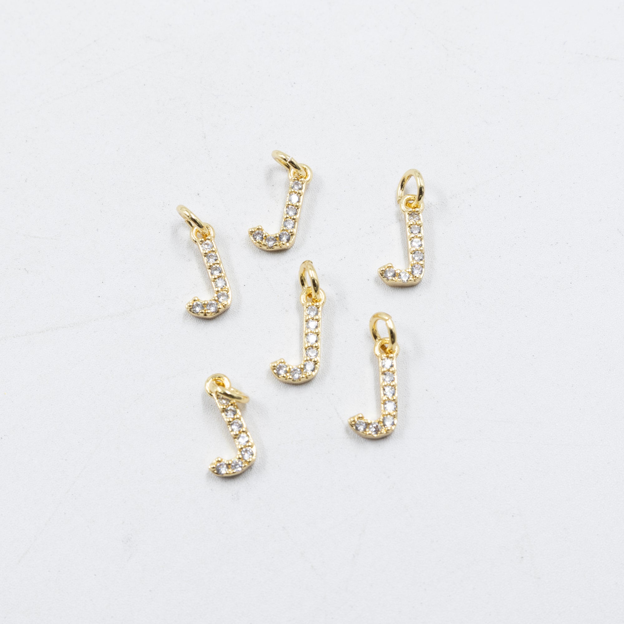 Paquete de 6 Dijes de Letras con piedras M1 Oro Laminado
